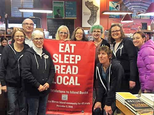 Staff of Island Books with a new Eat Sleep Read banner