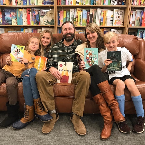 Author Kimmery Martin and her family posing with their favorite books at Park Road Books.