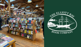 Inside Elliott Bay Book Company, Rows of wooden bookshelves stretch across a large room.