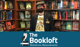 The Bookloft owner, Giovanni Boivin, stands in front of a bookshelf.