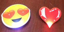 Yellow pin of smiley face with heart eyes, shiny red heart