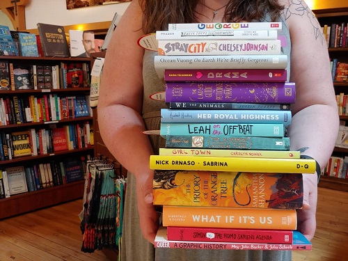 A bookseller holding a stack of books.