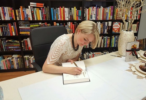 Partnering author Chelsea Bobulski signs books at Gathering Volumes