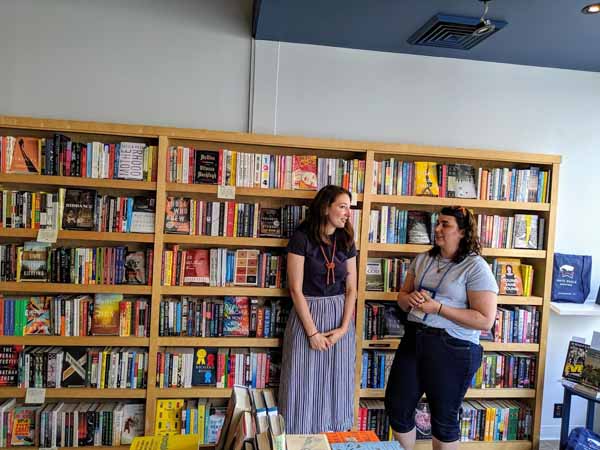Jill Yeomans with a bookseller in front of a set of bookshelves at White Whale Bookstore