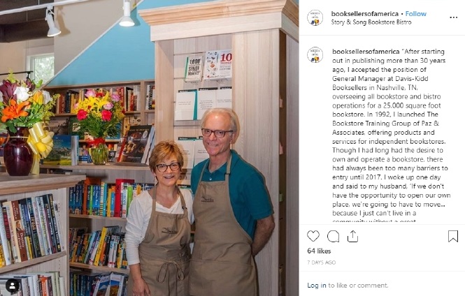 Two booksellers in brown aprons standing in their bookstore