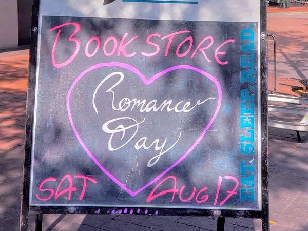 A sign promoting Bookstore Romance Day at Rediscovered Books.
