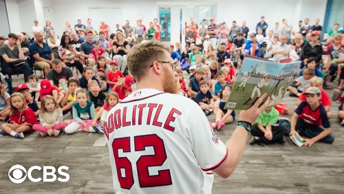 Sean Doolittle reading a picture book to a crowd of kids